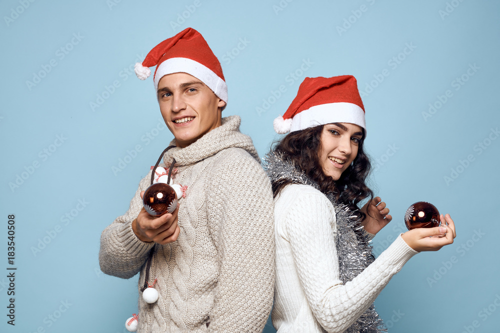 2127671 a couple is standing with their backs to each other and holding in their hands Christmas balls, a new year 2127671 a couple is standing with their backs to each other and holding in their hands Christmas balls, a new year