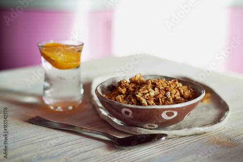 Healthy Breakfast of Champions. Muesli , a glass of water with a slice of orange. Ceramic handmade