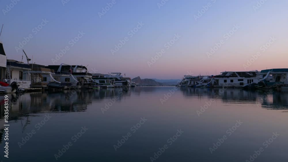 Rows of houseboats in shimmering lake at sunset / Lake Powell, Arizona, United States Rows of houseboats in shimmering lake at sunset / Lake Powell, Arizona, United States