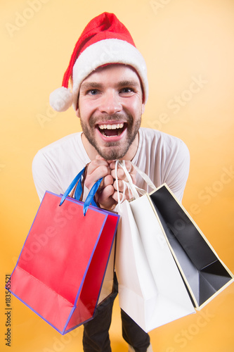 Man santa hold shopping bags on orange background