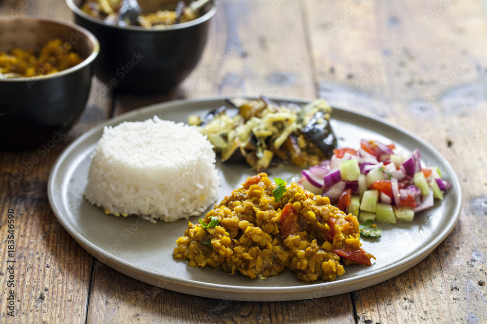 Indian meal with masoor dal - lentil curry, dahi baingan, rice and salad Indian meal with masoor dal - lentil curry, dahi baingan, rice and salad