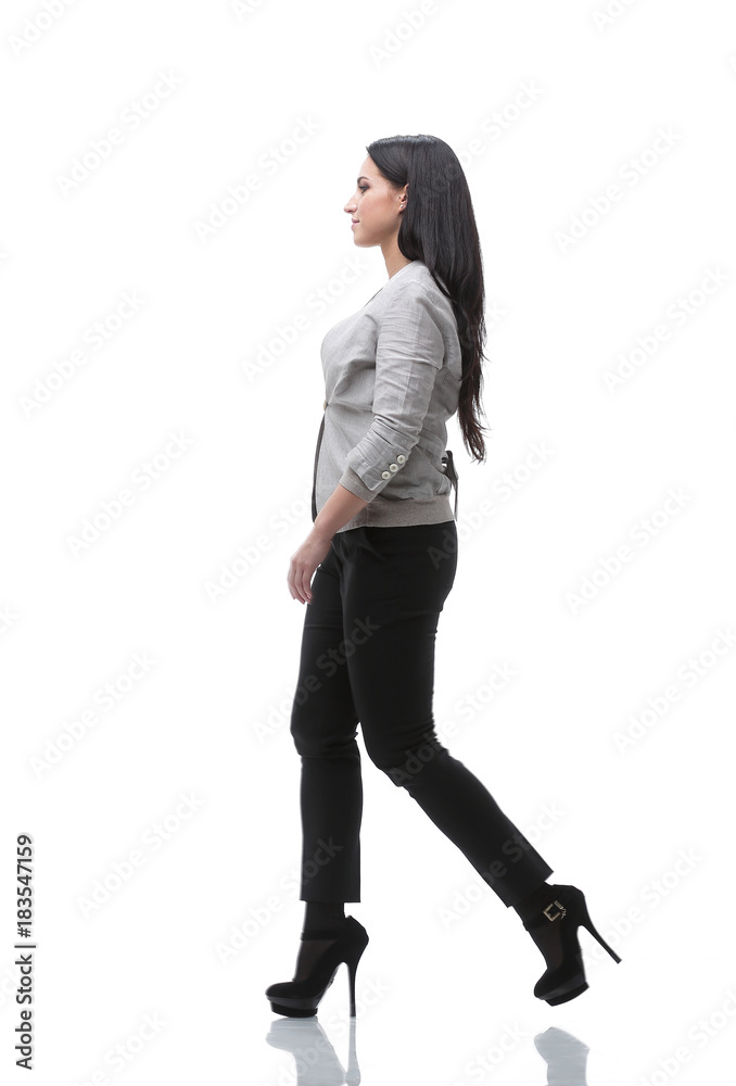 full-length. side view. modern young woman confidently goes forward full-length. side view. modern young woman confidently goes forward