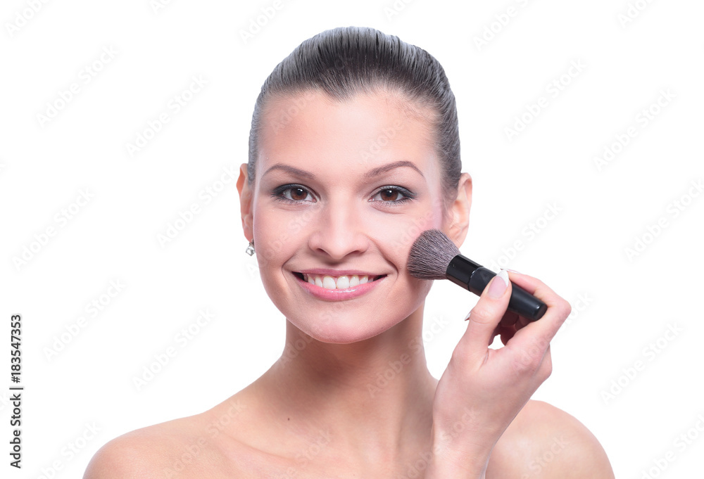 Woman applying dry cosmetic tonal foundation on the face using m Woman applying dry cosmetic tonal foundation on the face using m