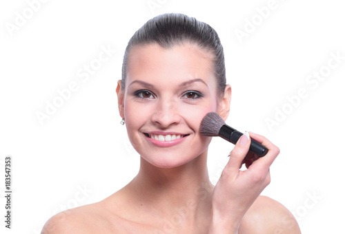 Woman applying dry cosmetic tonal foundation on the face using m