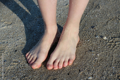 Shy Girl Feet Standing In a Sand.