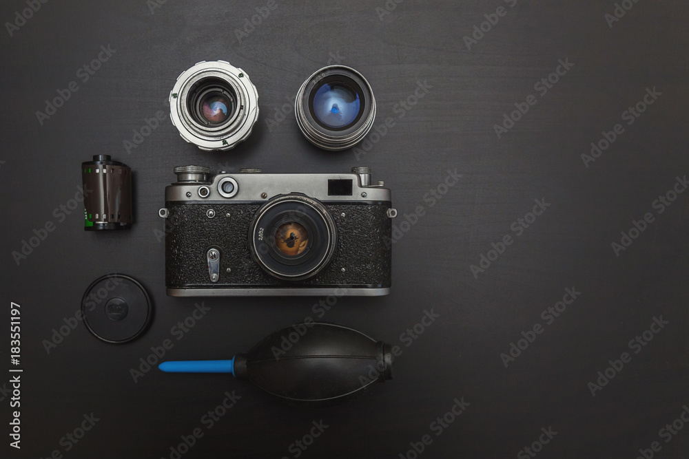 Vintage Film Camera And Accessories On Black Wooden Background Technology Development Concept with copy space. Top View