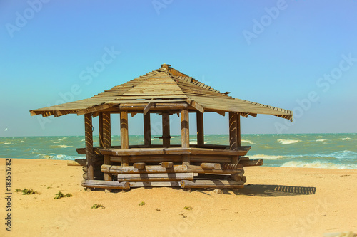 wooden pergola on the sandy beach of the sea © Yuri Bizgaimer
