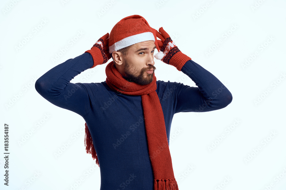 handsome man straightens the New Year's cap on his head, emotions, bright background, new year handsome man straightens the New Year's cap on his head, emotions, bright background, new year