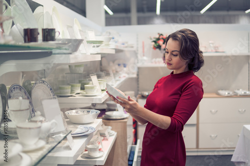 female customer choosing utensil dishes in the supermarket mall.