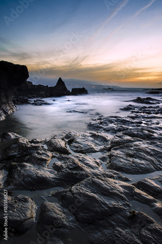 A long exposure of the rocky coast of Godrevy, Cornwall, England at sunset
