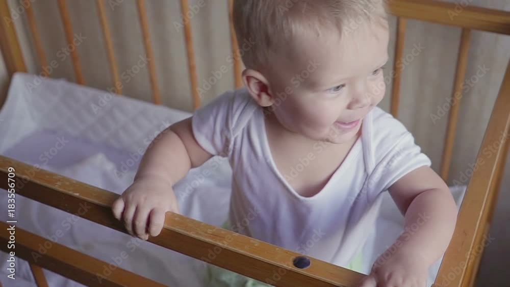 Kid in the crib looks around speaks, jumps and smiles. Kid in the crib looks around speaks, jumps and smiles.