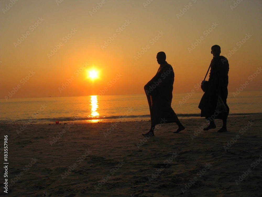 Monjes budistas al atradecer en playa de Ko Samet,isla en la provincia de Rayong, Tailandia, situada en el golfo de Tailandia al sur de Bangkok