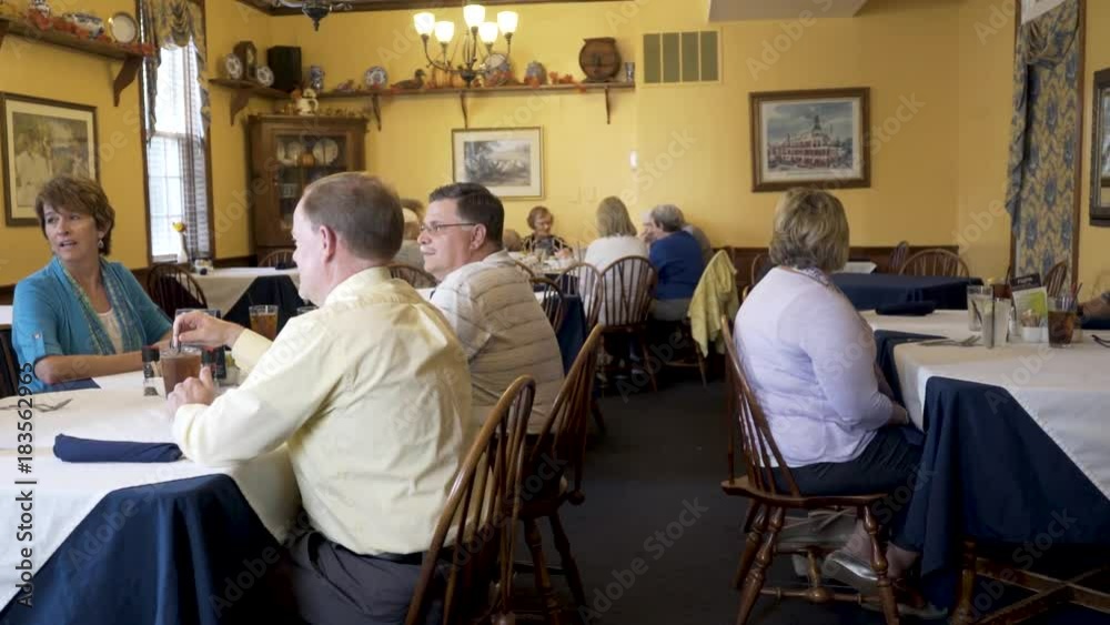 Business people talk and laugh while waiting for their food to be delivered at a restaurant. Business people talk and laugh while waiting for their food to be delivered at a restaurant.
