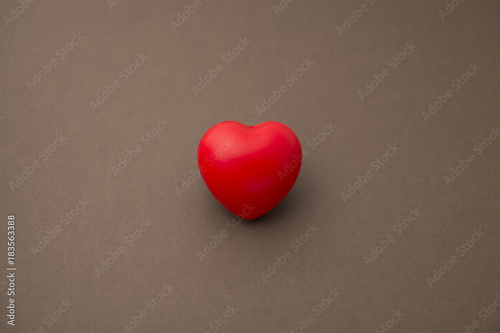 Single Red Rubber or 3D Heart Isolated on Brown Background Single Red Rubber or 3D Heart Isolated on Brown Background