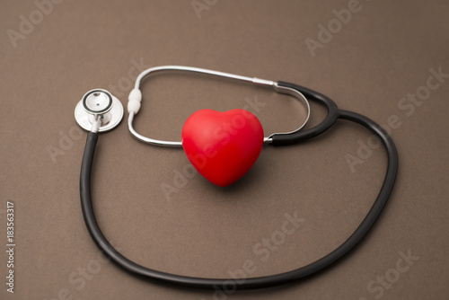 Red Rubber Heart and Stethoscope on Brown Background