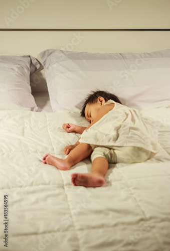 baby sleeping on bed at home