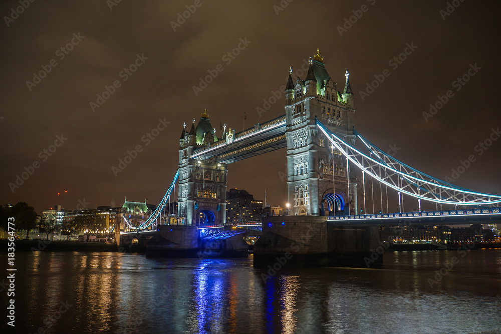 Obraz premium Londyn / Wielka Brytania - 18 listopada 2017: Tower Bridge w nocy z oświetleniem w pochmurne niebo