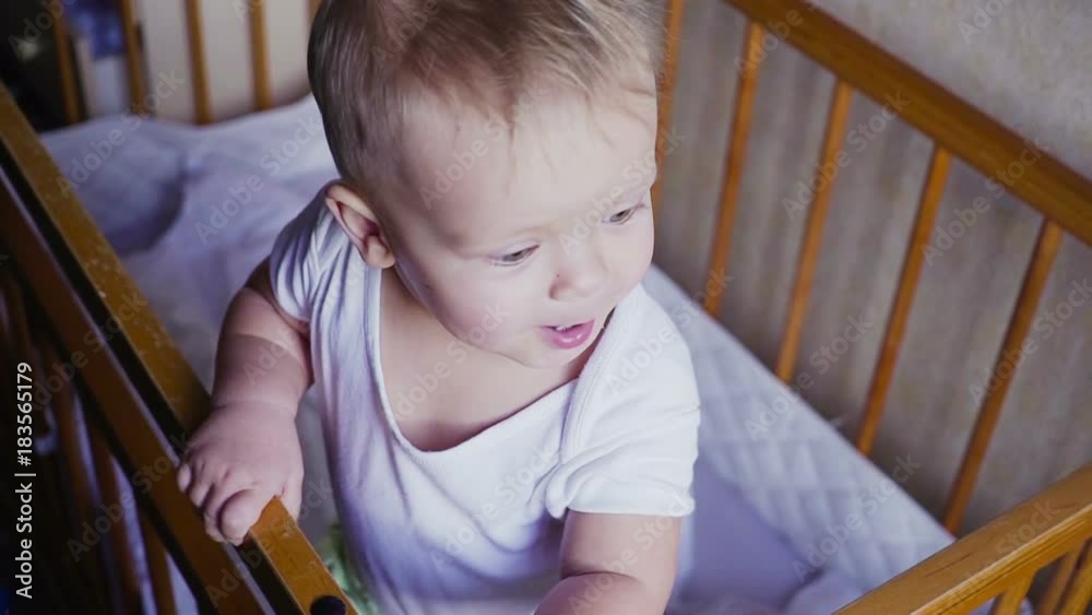 Kid in the crib looks around speaks, jumps and smiles. Kid in the crib looks around speaks, jumps and smiles.