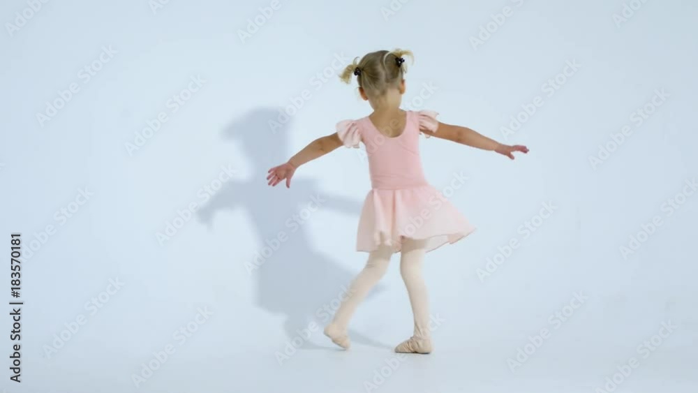 A small ballerina dances with enthusiasm. The girl is engaged in ballet A small ballerina dances with enthusiasm. The girl is engaged in ballet