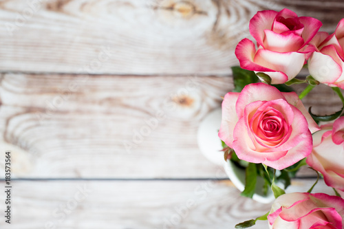 Pink roses on wooden background with empty space for text