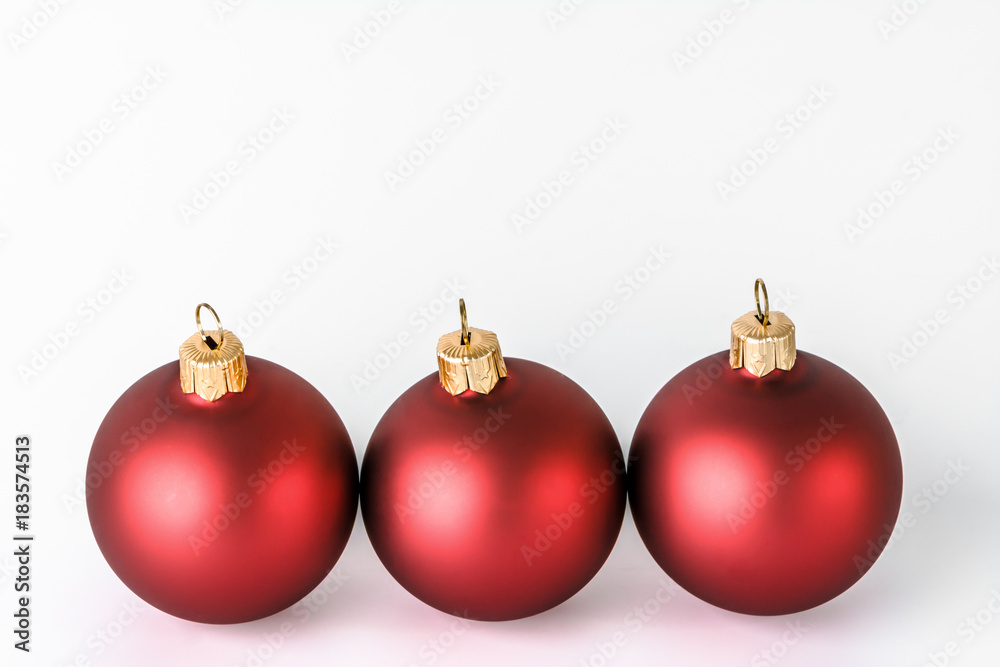Christmas ornaments isolated on white background. Decoration on card, red shiny baubles with reflections.
