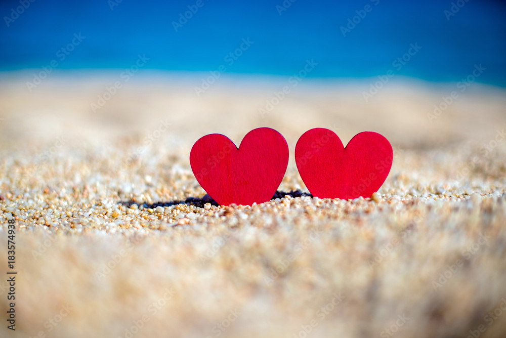 Fototapeta premium romantic symbol of two hearts on the beach