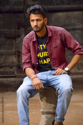 Young man with checked shirt looking at camera, Pune, Maharashtra.