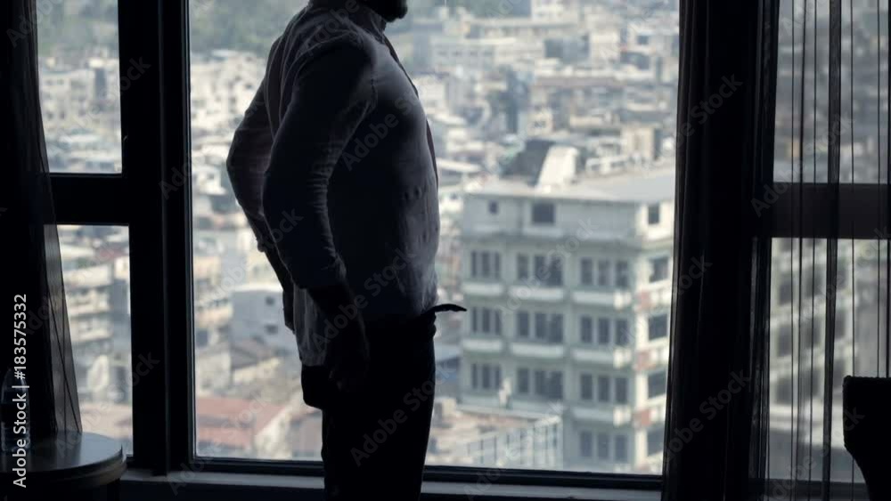 Young man putting on trousers standing by window at home
Young man putting on trousers standing by window at home