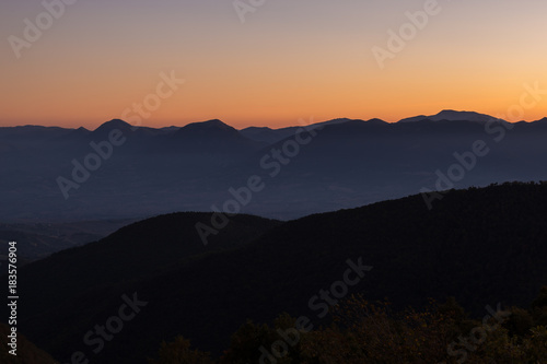 Silhouette of mountain layers at sunset, under an empty sky with beautiful tones and colors
