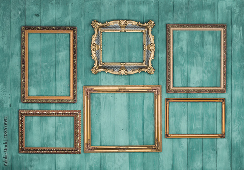 gallery of vintage victorian golden frames isolated on green wooden wall, framework