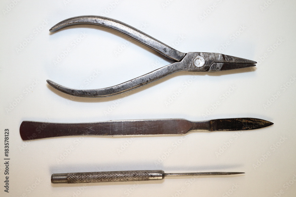 tool for work, metal pliers, scalpel and awl against white background tool for work, metal pliers, scalpel and awl against white background