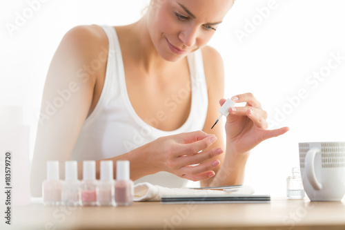 woman painting nails at home