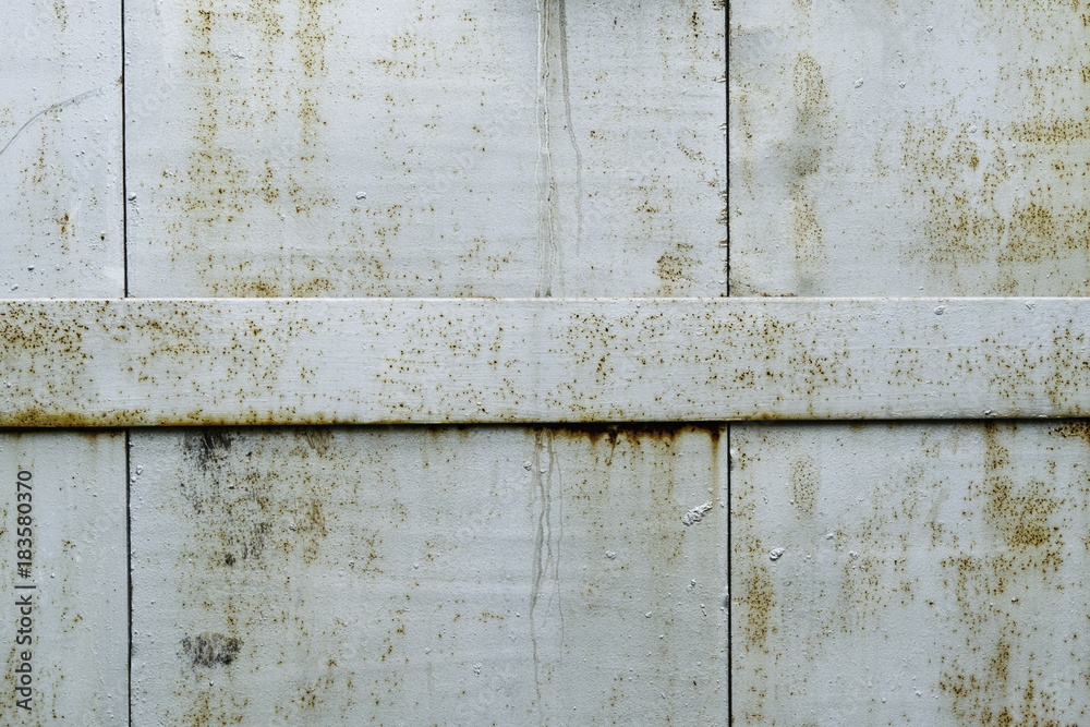 Detail of old metal doors reinforced with steel bands. Weathered cross steel metallic texture elements of the old door. Industrial background Detail of old metal doors reinforced with steel bands. Weathered cross steel metallic texture elements of the old door. Industrial background