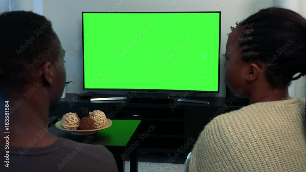 Young black couple watch television in living room - green screen - closeup Young black couple watch television in living room - green screen - closeup