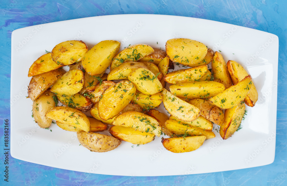 Baked potato slices with herbs in a white dish Baked potato slices with herbs in a white dish