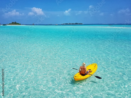 A man sit on kayak. Floating in the beautiful sea.  photo