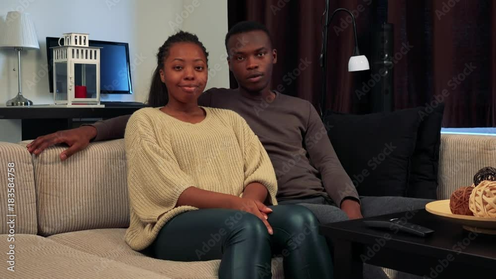 Young black happy couple talk to camera together in living room Young black happy couple talk to camera together in living room