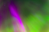 Polar lights Aurora Borealis in the night starry sky, texture and purple and green colored natural phenomena.