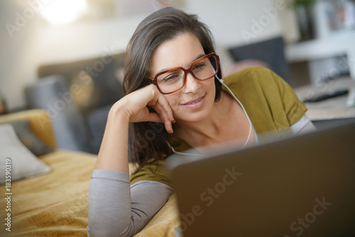 Φωτογραφία Trendy woman relaxing at home connected with laptop
