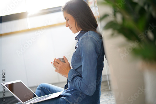 Woman sitting on floor connected with laptop
