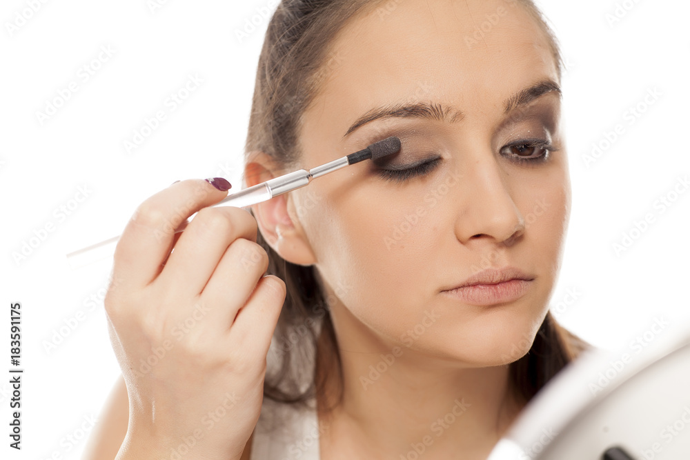 young beautiful woman applied eyeshadow on her eyelids