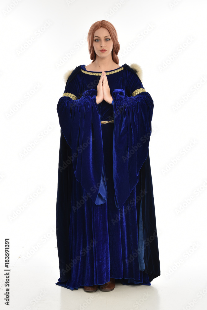 full length portrait of girl wearing long blue velvet gown and fur lined cloak, standing pose on white background. full length portrait of girl wearing long blue velvet gown and fur lined cloak, standing pose on white background.