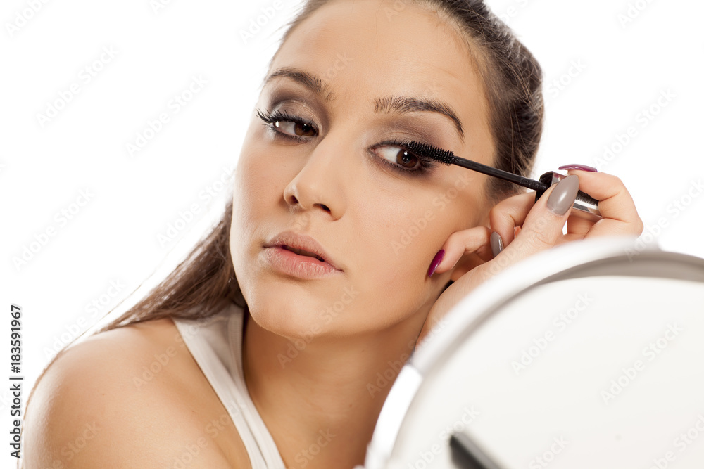 young beautiful woman applied mascara on her eyelashes young beautiful woman applied mascara on her eyelashes