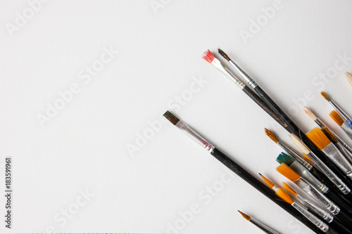 Art, Paint brushes over white canvas background with copy space.