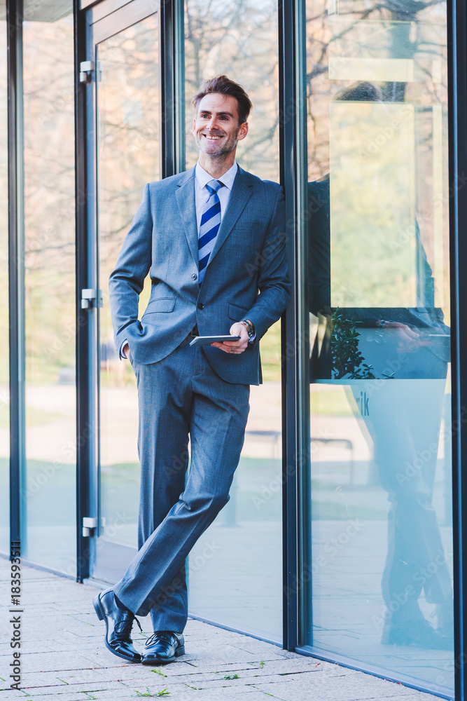 businessman at an office building with a tablet in the hand