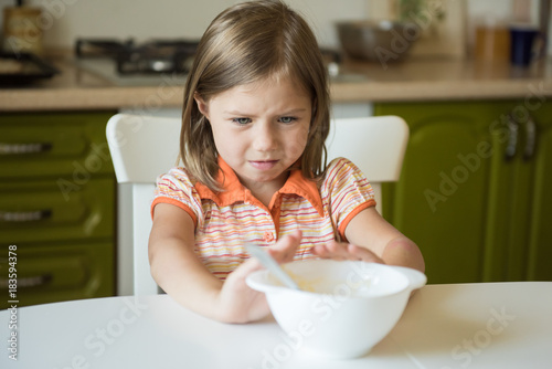 Fotografia Cute little girl refuses to eat, pushes the plate