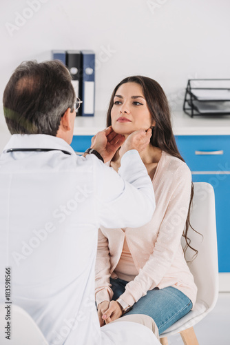male doctor palpating female patient lymph nodes