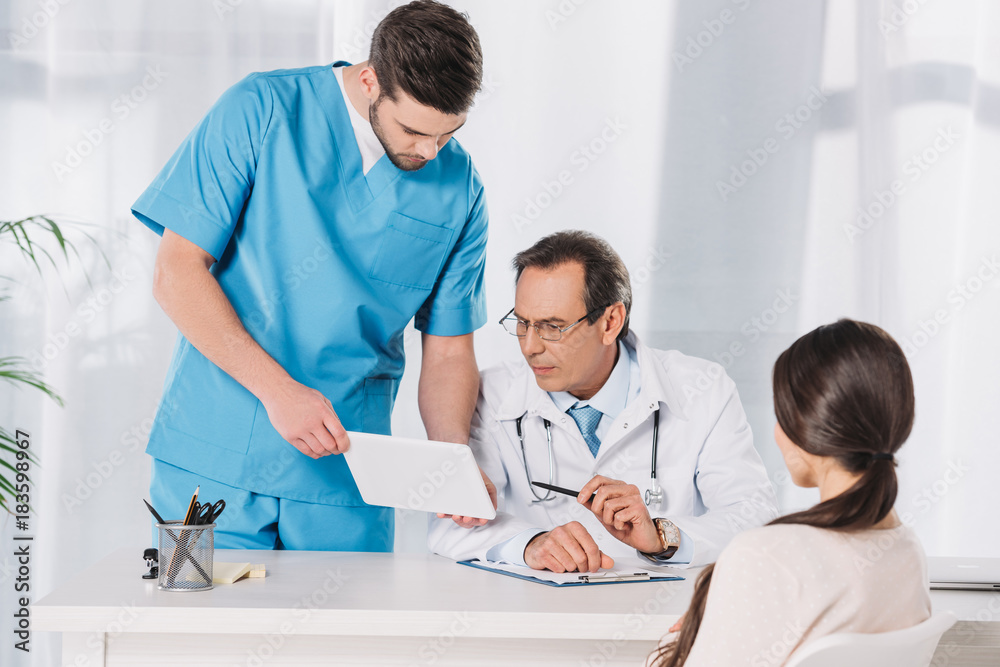 male nurse showing something to doctor on tablet male nurse showing something to doctor on tablet