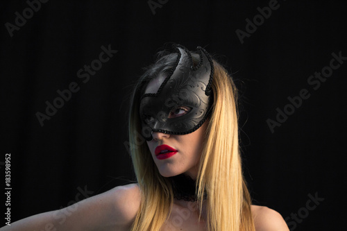 Mystic blonde woman in mask on dark background © Adriana Nikolova