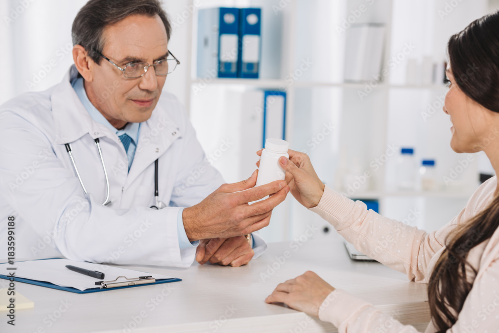 doctor giving pills to female patient doctor giving pills to female patient